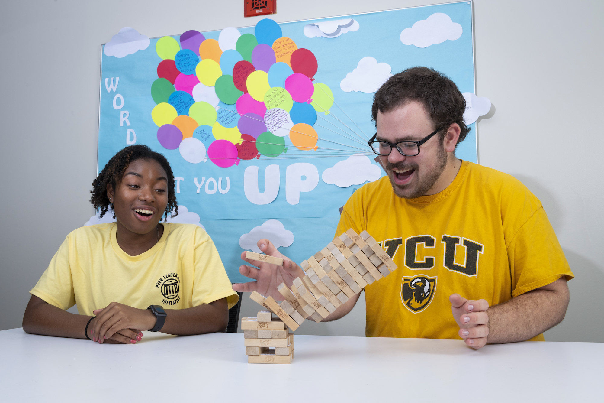 Two residents playing jenga in the community room of Rhoads and Brandt Hall